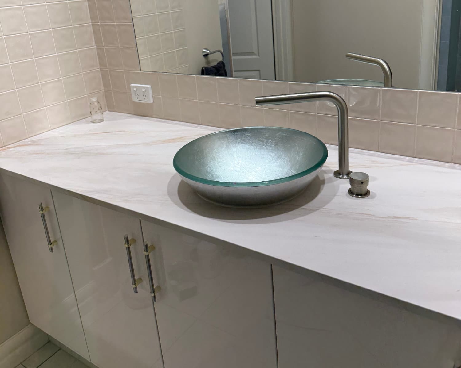 Bathroom vanity fit out with a glass vessel basin and floor mounted tapware