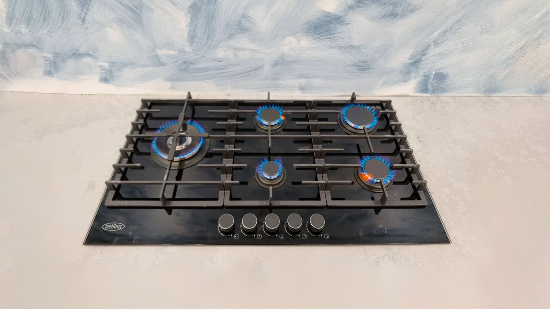 Five burner gas cooktop installation, burners lit