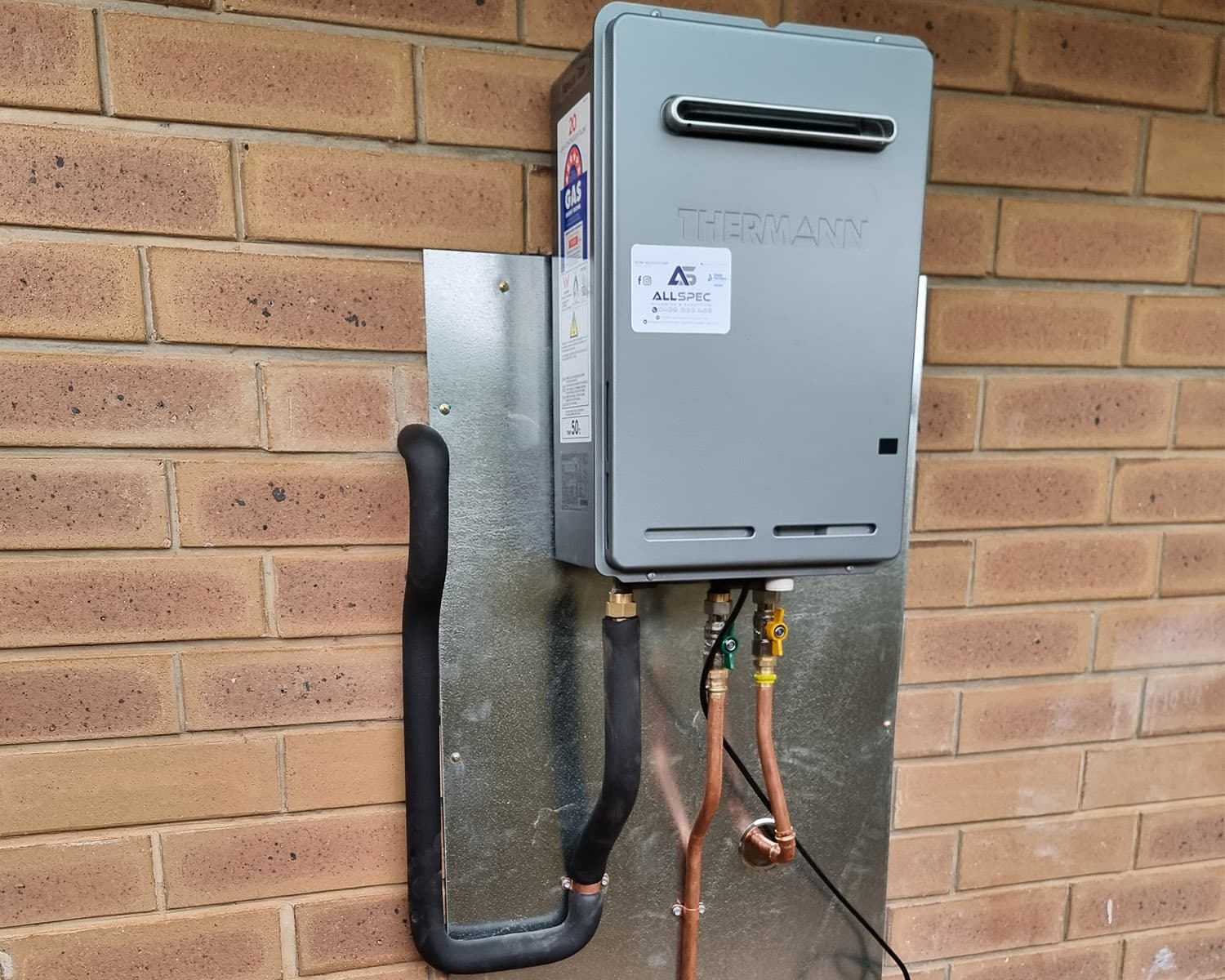 Thermann continuous flow gas hot water unit installed on an exterior brick wall